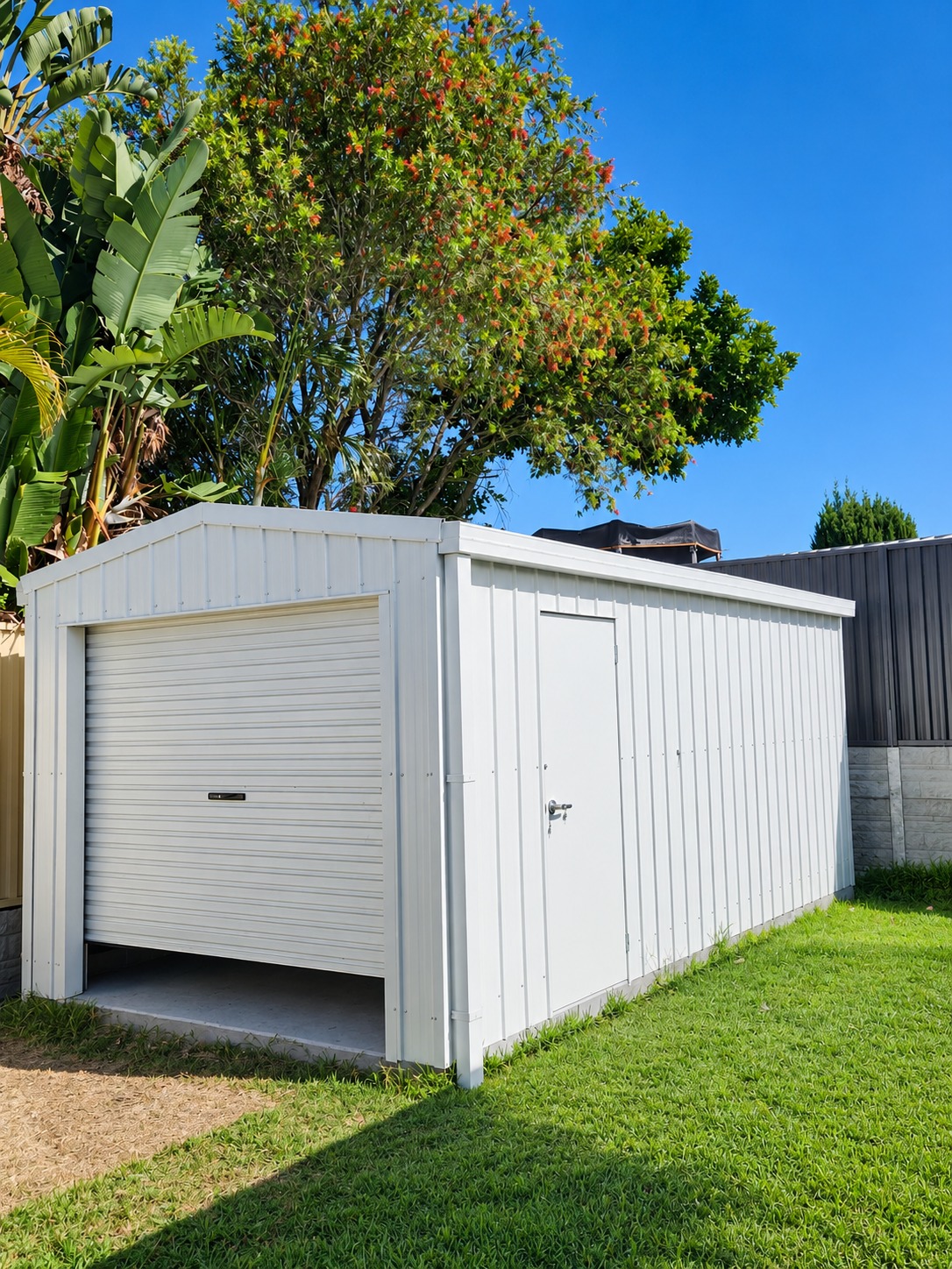 White shed with roller door and personal access door